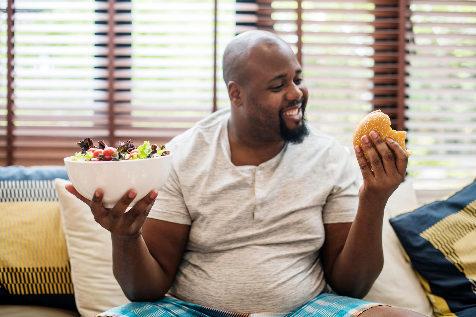 An overweight black man choosing what to eat